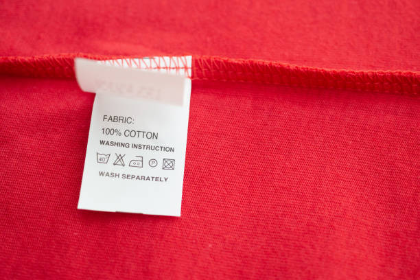 white laundry care washing instructions clothes label on red cotton shirt - scale industry copy space special imagens e fotografias de stock