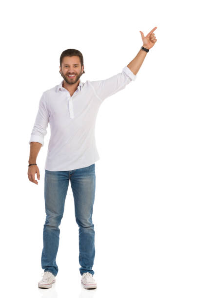 istock Handsome Young Man Is Standing With Arm Raised, Pointing Up And Smiling 1212440744