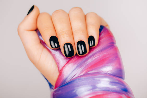 istock hands with black manicure holding slime 1212440799