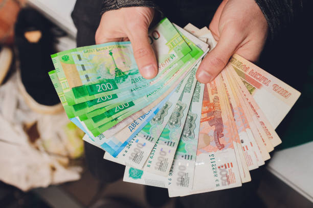istock Rubles in hands. Stack of money. Black background. 1212440900