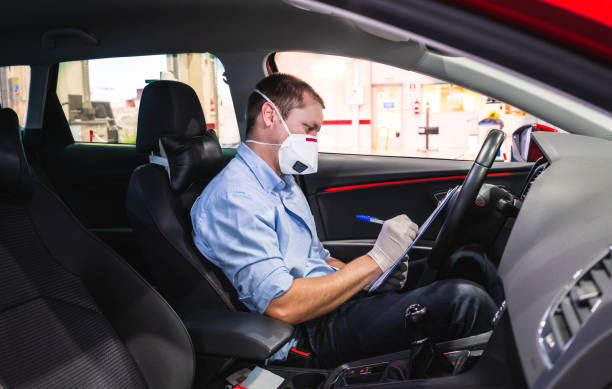 a technician doing a security inspection inside a vehicle protected with a mask and gloves to prevent the spread of virus - illness mask pollution car imagens e fotografias de stock