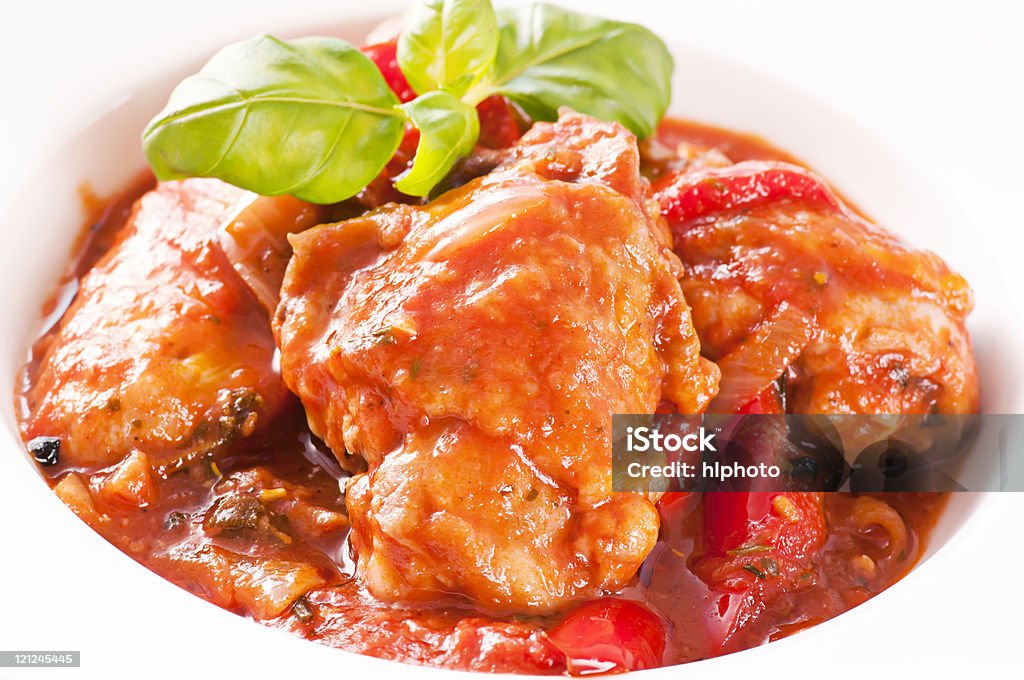 Chicken cacciatore against white background Chicken with spicy tomato souce and vegetable as closeup on a white plate Cacciatore Stock Photo