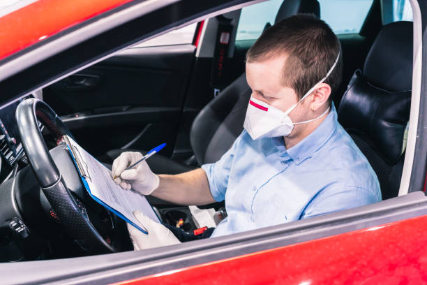 a technician doing a security inspection inside a vehicle protected with a mask and gloves to prevent the spread of virus - illness mask pollution car imagens e fotografias de stock