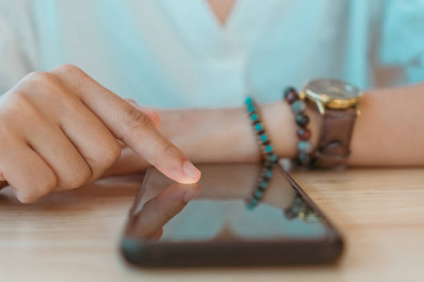istock Woman feel happy and smile while using smartphone to do work business, social network, communication in public cafe work space area. 1212462566