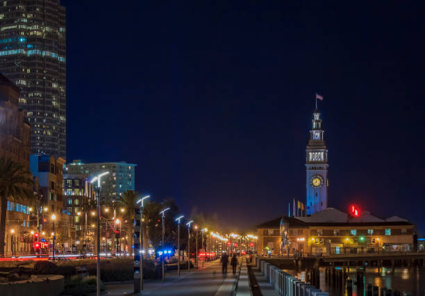 vista dello skyline della città nel quartiere finanziario lungo il lungomare e ferry building di notte, san francisco, stati uniti - san francisco county embarcadero center bay bridge built structure foto e immagini stock