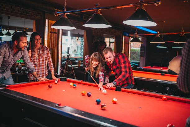 istock Young happy people having fun while playing billiard in a pub 1212467720