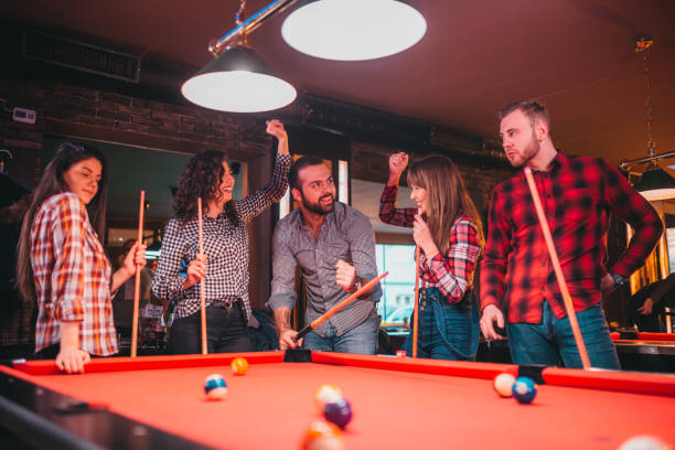 istock Young happy people having fun while playing billiard in a pub 1212467738