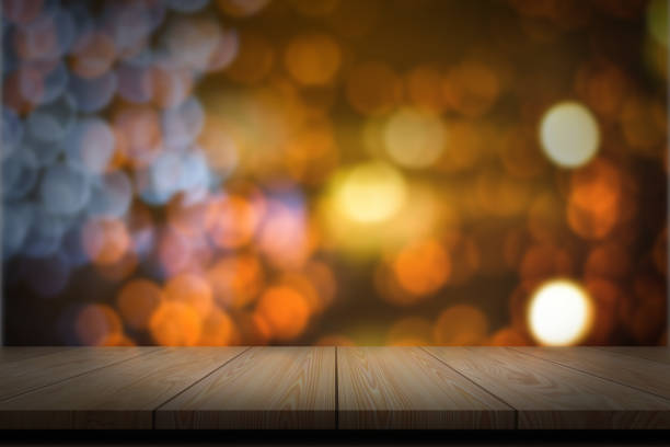 Empty wooden table with abstract blurred bokeh lights background for product display.