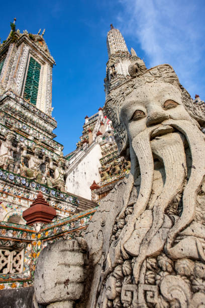 charyzmatyczna stara kamienna, rzeźbiona w stylu chińskim figura zdobiąca podstawę centralnej stupy w wat arun. - wat arun buddhism temple stone zdjęcia i obrazy z banku zdjęć