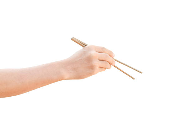 istock hand holding wooden chopsticks isolated on white background with clipping path. 1212479751