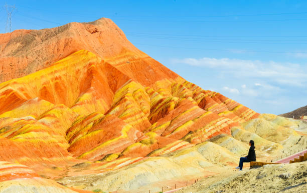 Young girl enjoys beautiful Danxia landscape Young girl enjoys beautiful Danxia landscape / Single young Asian girl enjoys the beautiful landscape in Zhangye Danxia Geological Park, Zhangye, Gansu, China zhangye danxia geopark china stock pictures, royalty-free photos & images