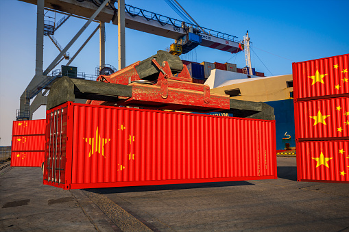 Unloading containers with the Chinese flag at the port quay