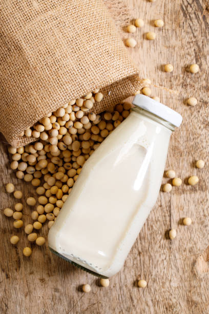 soia in sacchetto gunny e latte di soia in bottiglia di vetro - soybean merchandise soy milk milk foto e immagini stock