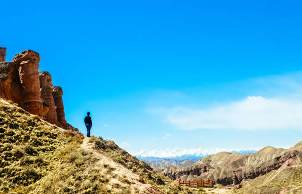 istock man looking far on hillside in Binggou Danxia Scenic Area 1212489068