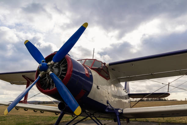 istock White biplane standing on airports with cloud sky 1212489121