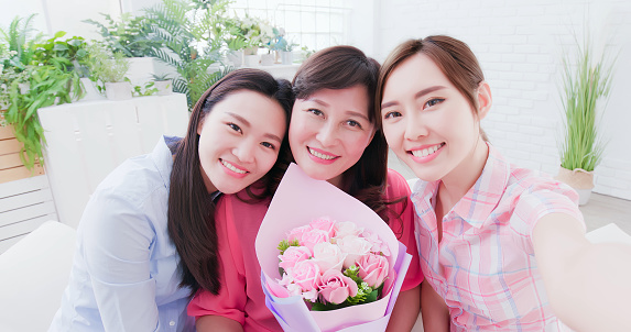 Daughters and mom take selfie together happily to celebrate mothers day