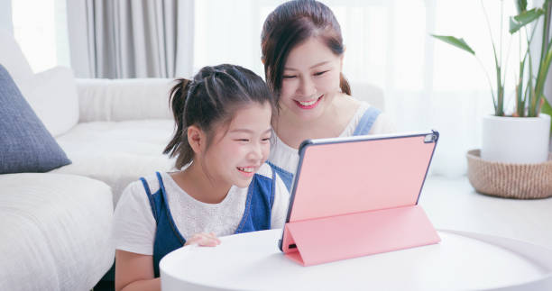 mamma e figlia usano il tablet - child digital tablet mother teaching foto e immagini stock