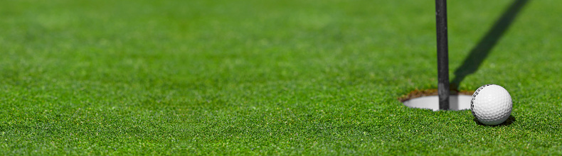 golf ball on lip of cup course background with copy space