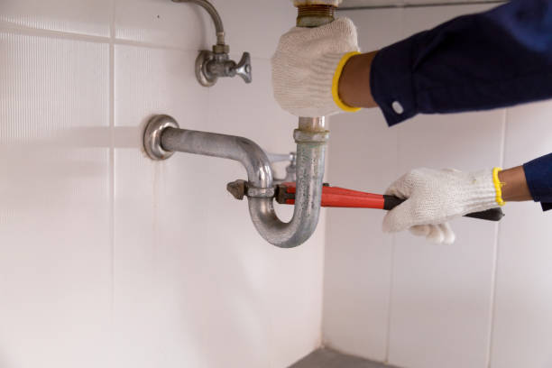istock Plumber fixing white sink pipe with adjustable wrench. 1212510498