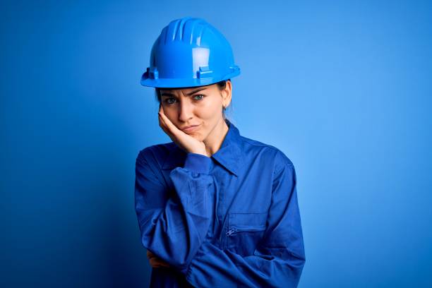 istock Young beautiful worker woman with blue eyes wearing security helmet and uniform thinking looking tired and bored with depression problems with crossed arms. 1212512613