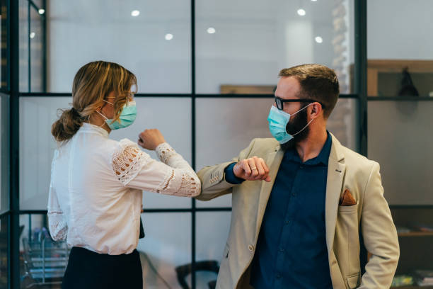 Business people greeting during COVID-19 pandemic Colleagues in the office practicing alternative greeting for safety and protection during COVID-19 viral infection photos stock pictures, royalty-free photos & images