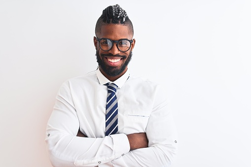 African american businessman with braids wearing tie glasses over isolated white background happy face smiling with crossed arms looking at the camera. Positive person.
