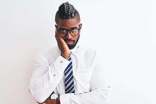 African american businessman with braids wearing tie glasses over isolated white background thinking looking tired and bored with depression problems with crossed arms.