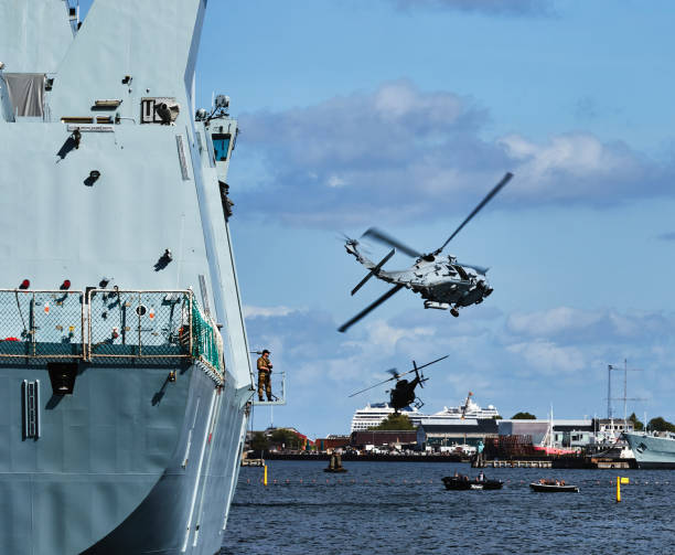 Halifax, Nova Scotia, Canada - August 16, 2011: A Canadian Military Sea King helicopter with crew in the cargo bay door doing a low flyby along the Halifax Waterfront.