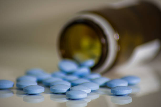 verschüttete blaue medizinische pillen aus braunem glas, kleine tabletten, die virenhelfen - pill medicine laboratory narcotic stock-fotos und bilder