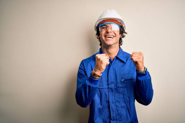 istock Young constructor man wearing uniform and security helmet over isolated white background excited for success with arms raised and eyes closed celebrating victory smiling. Winner concept. 1212519930
