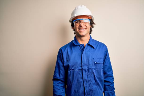 istock Young constructor man wearing uniform and security helmet over isolated white background winking looking at the camera with sexy expression, cheerful and happy face. 1212519984