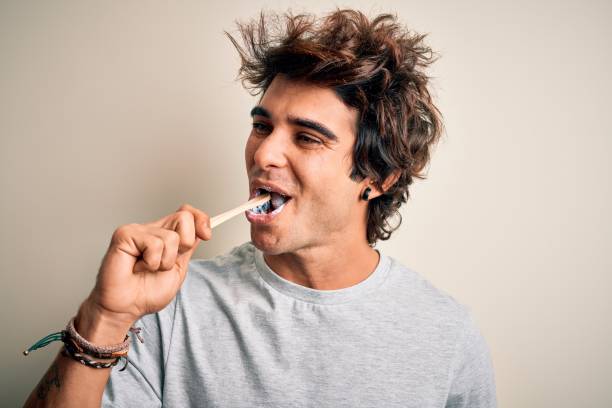 istock Young handsome man smiling happy. Standing with smile on face whasing tooth using toothbrush over isolated white background 1212520015