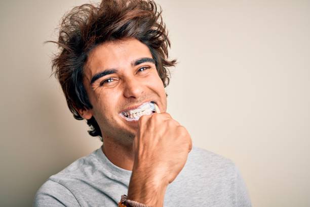 young handsome man smiling happy. standing with smile on face whasing tooth using toothbrush over isolated white background - hairstyle crest imagens e fotografias de stock