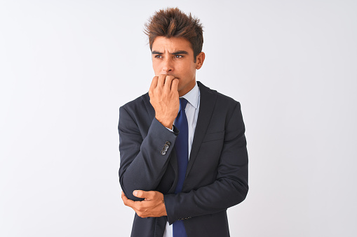 Young handsome businessman wearing suit standing over isolated white background looking stressed and nervous with hands on mouth biting nails. Anxiety problem.