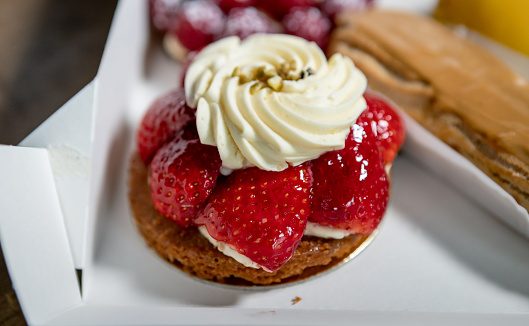 Strawberry tart bought in a pastry shop.
The tart is still in its transport box.
The photo was taken in daylight with the support of artificial light.