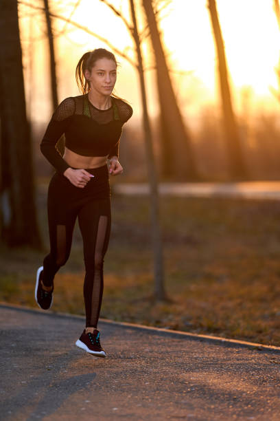 istock Young woman running in the park 1212526014
