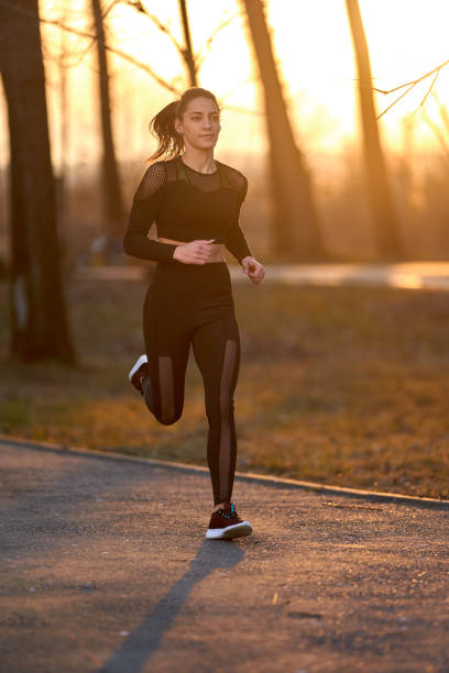 istock Young woman running in the park 1212526042
