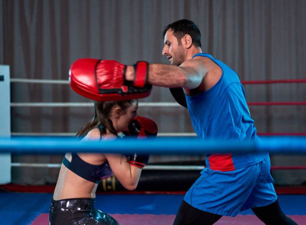 istock Kickboxing girl hitting mitts 1212526190