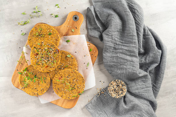 istock Raw veggie burger with lentils, vegetables and thyme leaves on kitchen countertop. Top view. Flat lay 1212529352