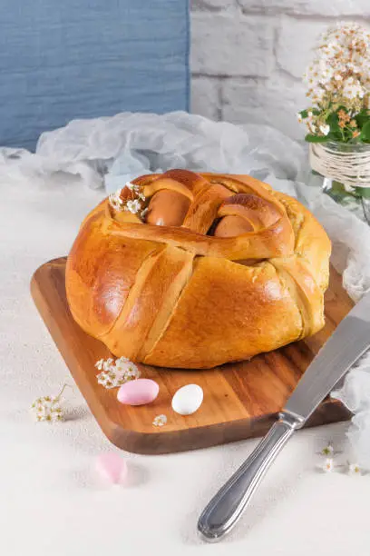 Photo of Portuguese traditional Easter cake. Folar with eggs on wooden table