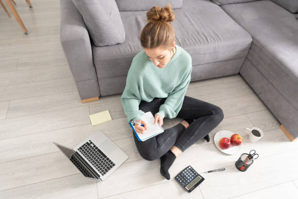 istock Young student learns at home on the floor 1212530590