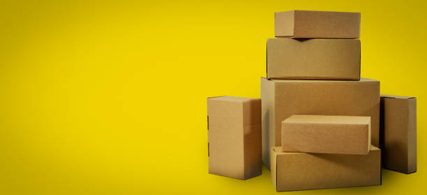 istock shipping and delivery - blank cardboard boxes on yellow background with copy space 1212532467