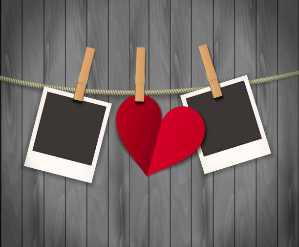istock Two photo frames and heart for valentines day hanging on rope on the wood background. Vector illustration. EPS 10 1212533695