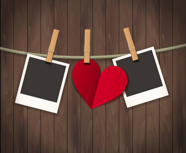 istock Two photo frames and heart for valentines day hanging on rope on the wood background. Vector illustration. EPS 10 1212533710