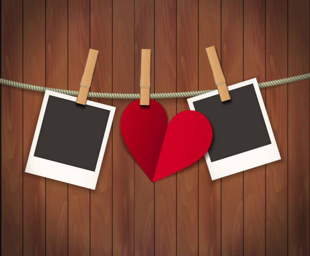 istock Two photo frames and heart for valentines day hanging on rope on the wood background. Vector illustration. EPS 10 1212533724