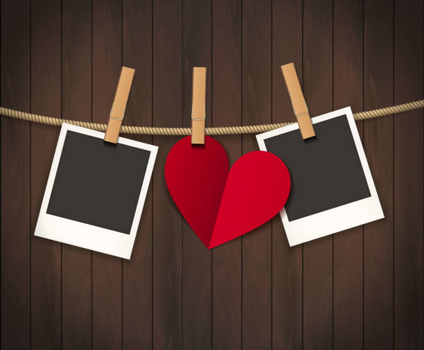 istock Two photo frames and heart for valentines day hanging on rope on the wood background. Vector illustration. EPS 10 1212533735