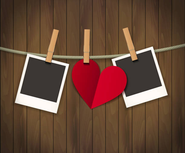 istock Two photo frames and heart for valentines day hanging on rope on the wood background. Vector illustration. EPS 10 1212533770