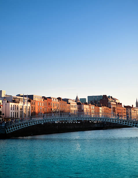 dublín y puente de ha'penny en río liffey al atardecer, irlanda - dublín fotografías e imágenes de stock