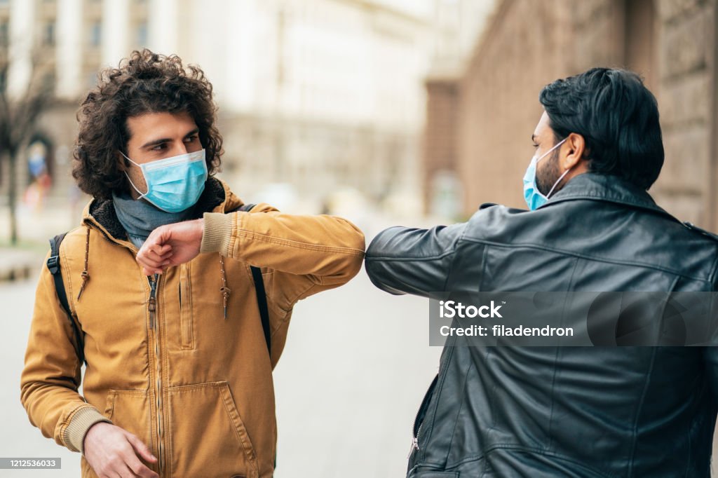 New style greetings in quarantine Young people friends meeting in quarantine and greeting without touching their hands Elbow Stock Photo