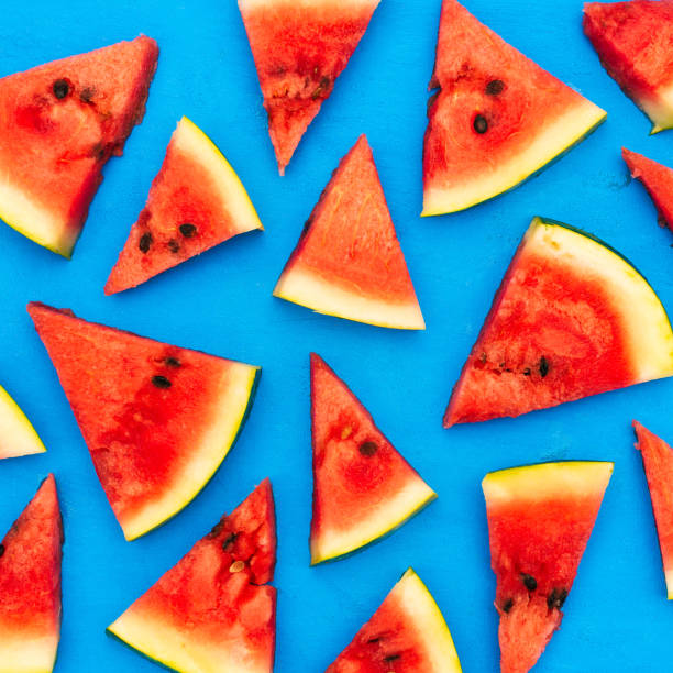 istock Slices of a watermelon triangular in shape on a blue background. Summer time concept. 1212536248
